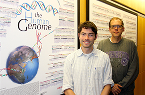 Tim Durham and Rob Fatland stand in front of a genome poster