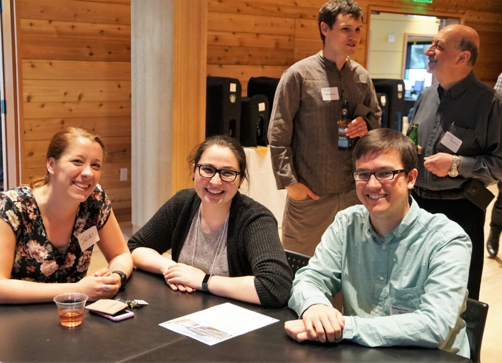 A small group of participants working at a table at the Waterhackweek Mixer. Photo, Yifan Cheng
