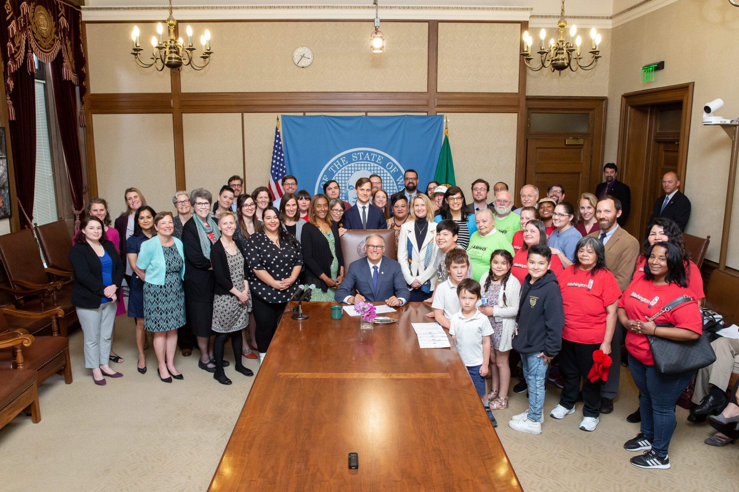 Gov. Inslee signs Engrossed Substitute Senate Bill No. 5600, May 9, 2019. Relating to residential tenant protections. Primary Sponsor: Patty Kuderer. Tim Thomas stands left of the Washington flag.