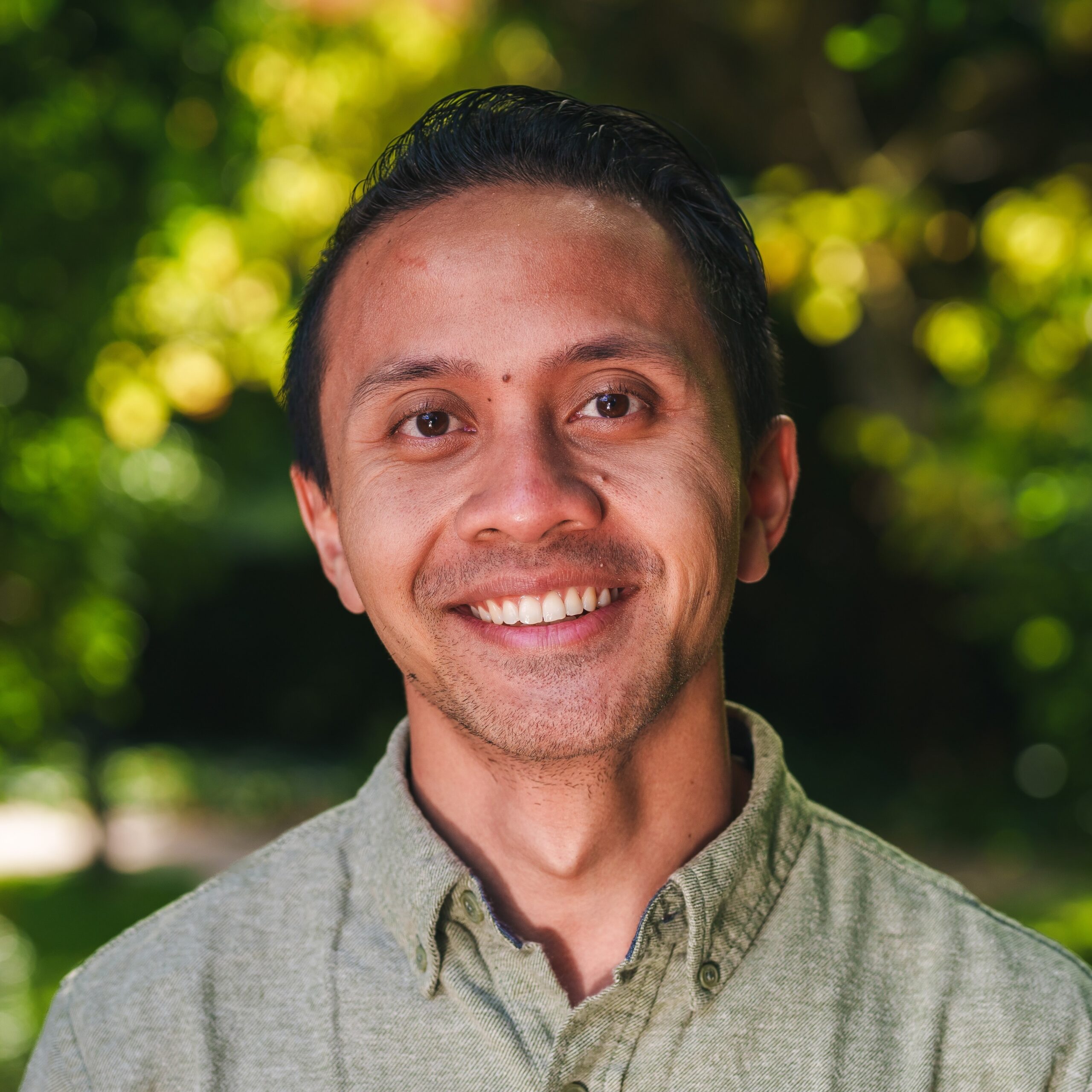 Don Setiawan smiling in front of a forest background